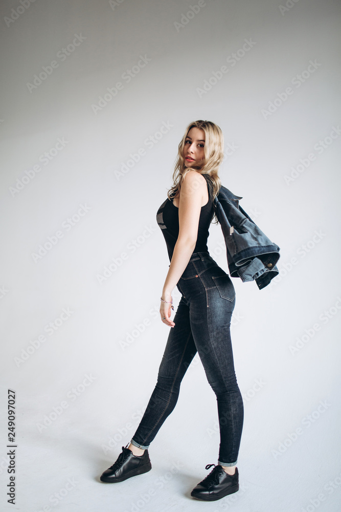 Portrait of a beautiful fashion woman, blonde, jeans, gray background Portrait of a beautiful fashion woman, blonde, jeans, gray background