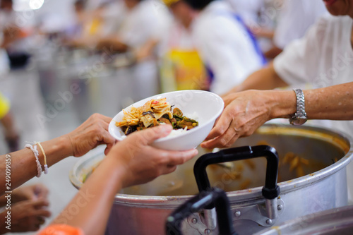 Volunteers are giving food to the homeless poor : the concept of humane