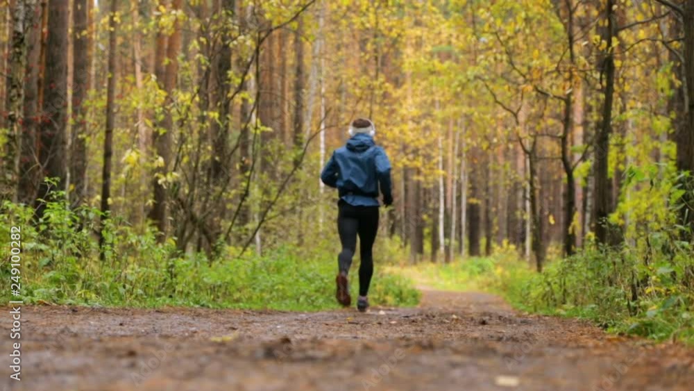 Man is running in autumn park