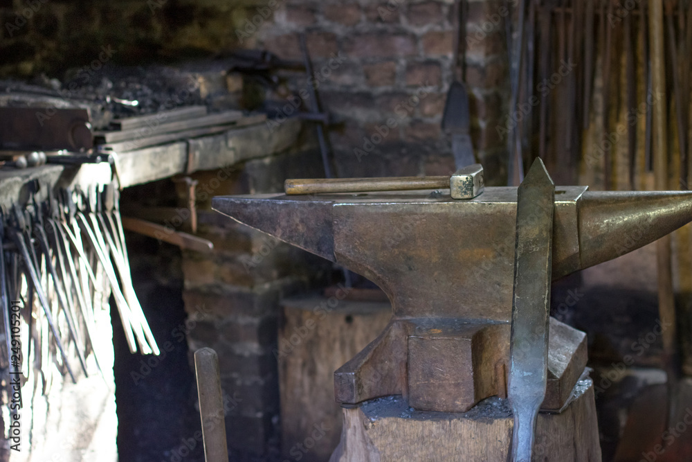 A hammer and a metal object in the forge A hammer and a metal object in the forge