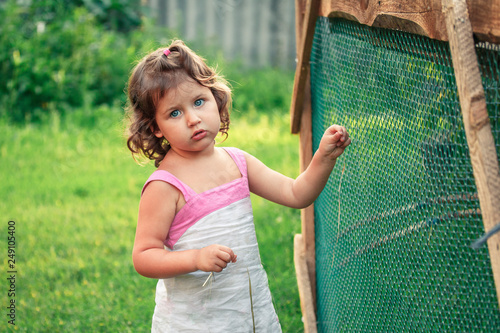 Sad country girl in old dress near barn for chickens