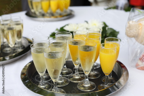 tray at a reception with glasses filled with champagne and orange juice