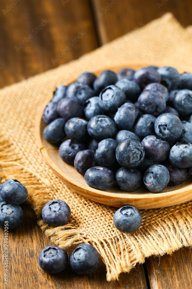 Fresh blueberries in wooden plate on a wooden table Fresh blueberries in wooden plate on a wooden table