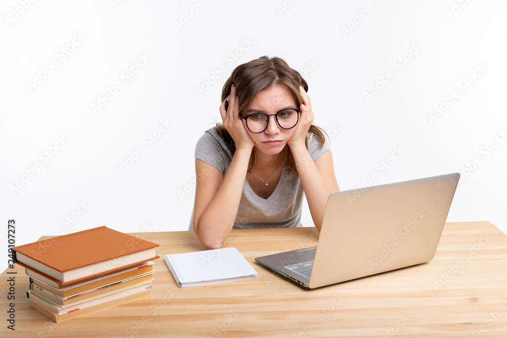 Study, education and people concept - young student woman working at laptop looking very tired Study, education and people concept - young student woman working at laptop looking very tired