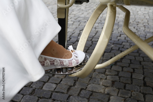 Detail of bride stepping in the wedding carriage with luxury white shoes