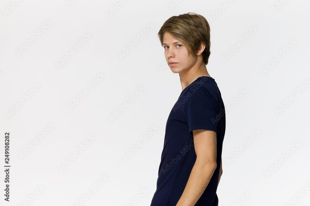 Cheerful smiling teenager in blue t-shirt against white background studio shot, isolated Cheerful smiling teenager in blue t-shirt against white background studio shot, isolated