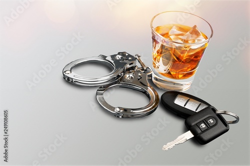 Whiskey with car keys and handcuffs concept for drinking and driving photo