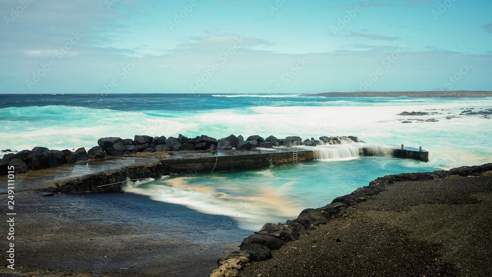 FEBRUARY/02/2019 Waves jumping on dock of the fishing cove of La Santa in Lanzarote during a storm, long exposure photography