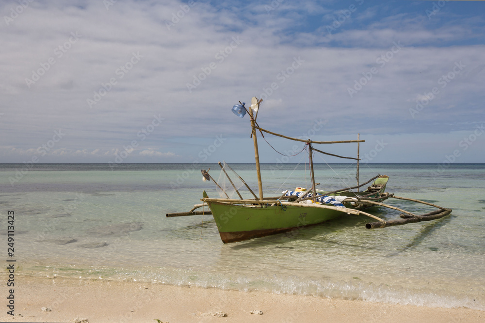 old fishing boat outrigger with self made Fishing light attractor in a  white beach with crystal clear water Stock Photo | Adobe Stock