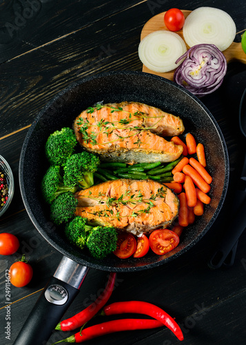 grilled salmon fillet with broccoli and vegetables in a pan