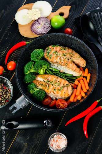 grilled salmon fillet with broccoli and vegetables in a pan