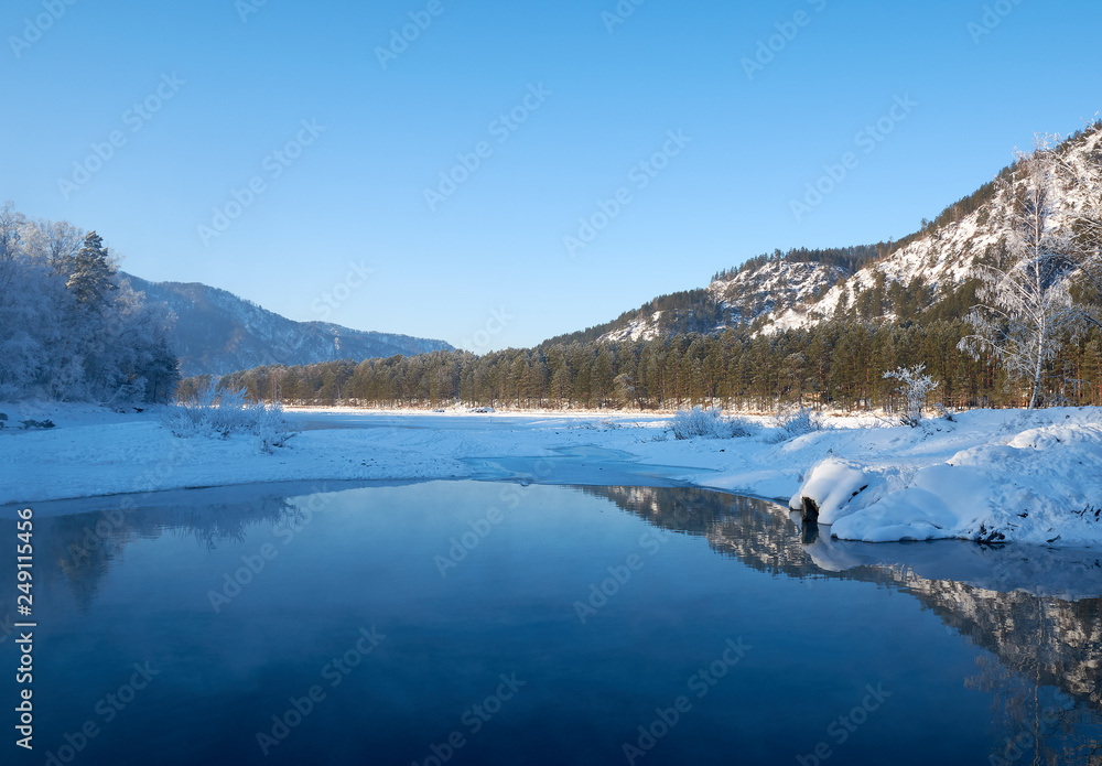 The river in the blue clear clear water flowing in the mountains in the winter sunset evening.