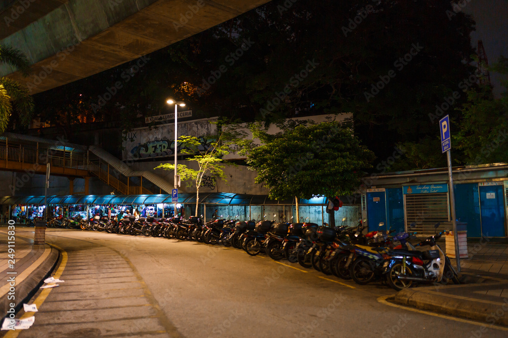Kuala Lumpur, Malaysia - 13th February, 2018: Kuala Lumpur night street with motorbike parking lot