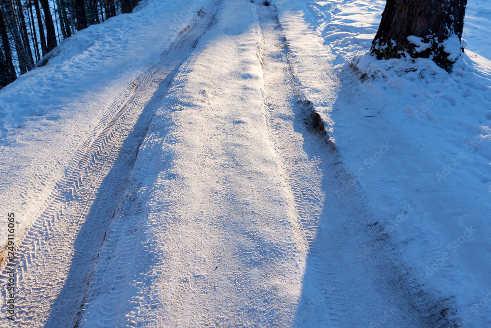 scenic view of empty road with snow covered landscape while snowing in winter season.