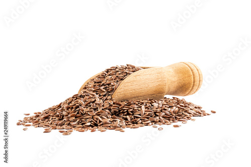 Heap of linseeds og flax seed with a small wooden scoop seen from low angle and isolated on white background