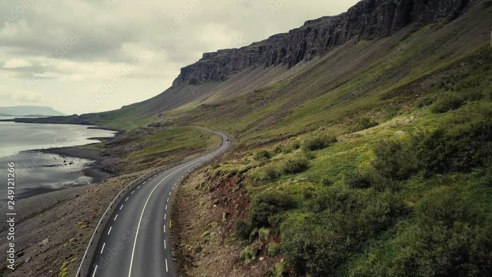 Drone following a beautiful mountain road leading through Iceland, with scenic mountains on the right side, the Sea to the left. Drone following a beautiful mountain road leading through Iceland, with scenic mountains on the right side, the Sea to the left.