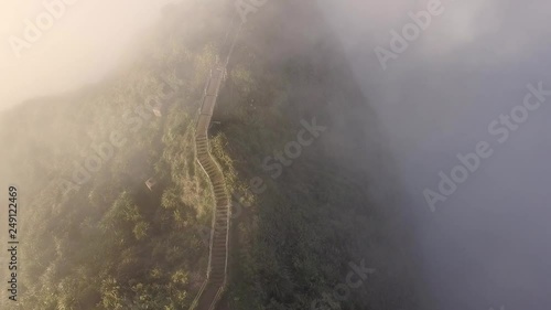 Clouds pass over an upper segment of the Haiku Stairs on Oahu photo