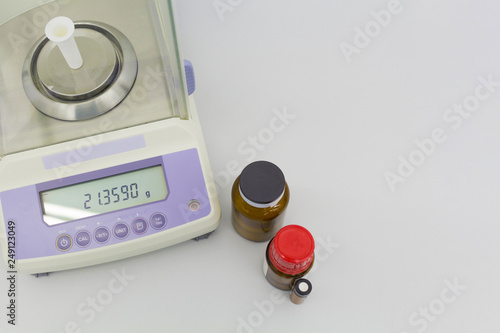 laboratory scale on table with materials in bottles.