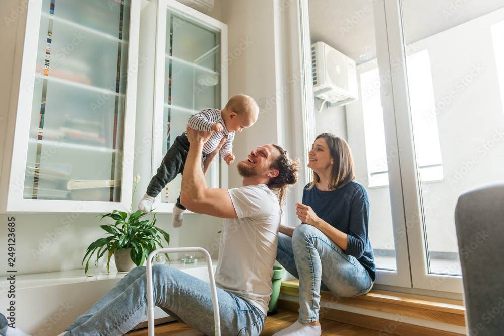 Fototapeta premium Young parents playing with baby