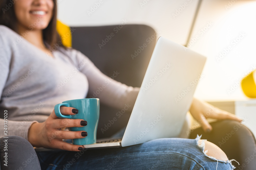 Naklejka premium close up of woman holding cup of coffee and laptop