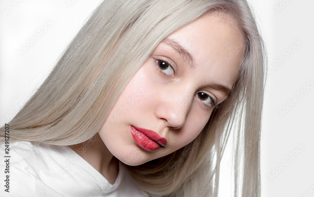 portrait of a young girl with blond hair and red lipstick on the lips on a white background close up portrait of a young girl with blond hair and red lipstick on the lips on a white background close up