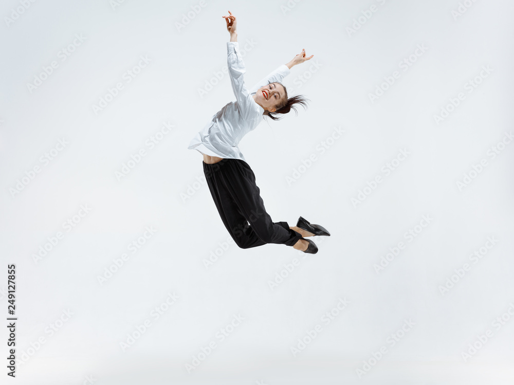 Happy businesswoman dancing and smiling in motion isolated on white studio background. Flexibility and grace in business. Human emotions concept. Office, success, professional, happiness, expression