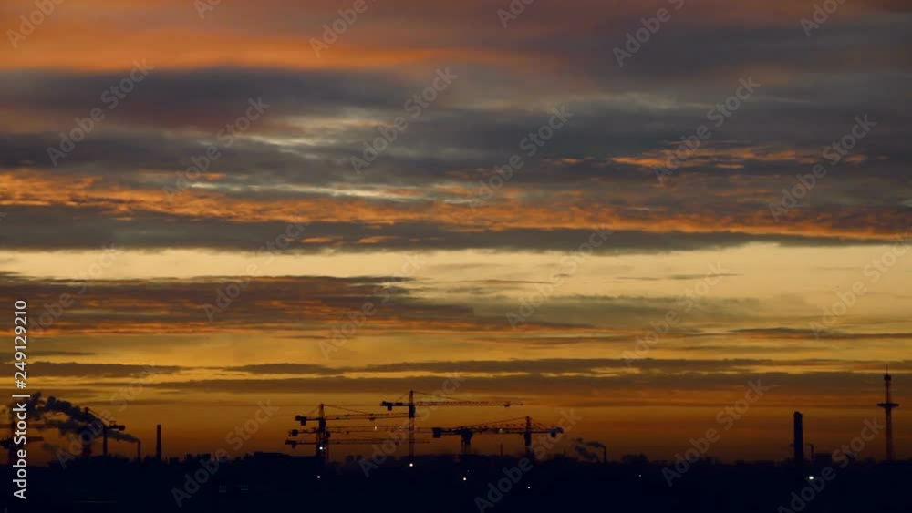 Beautiful sunset sky and cranes silhouettes against evening colorful clouds. Camera locked down. Selective focus. Pink Beautiful sunset sky and cranes silhouettes against evening colorful clouds. Camera locked down. Selective focus. Pink