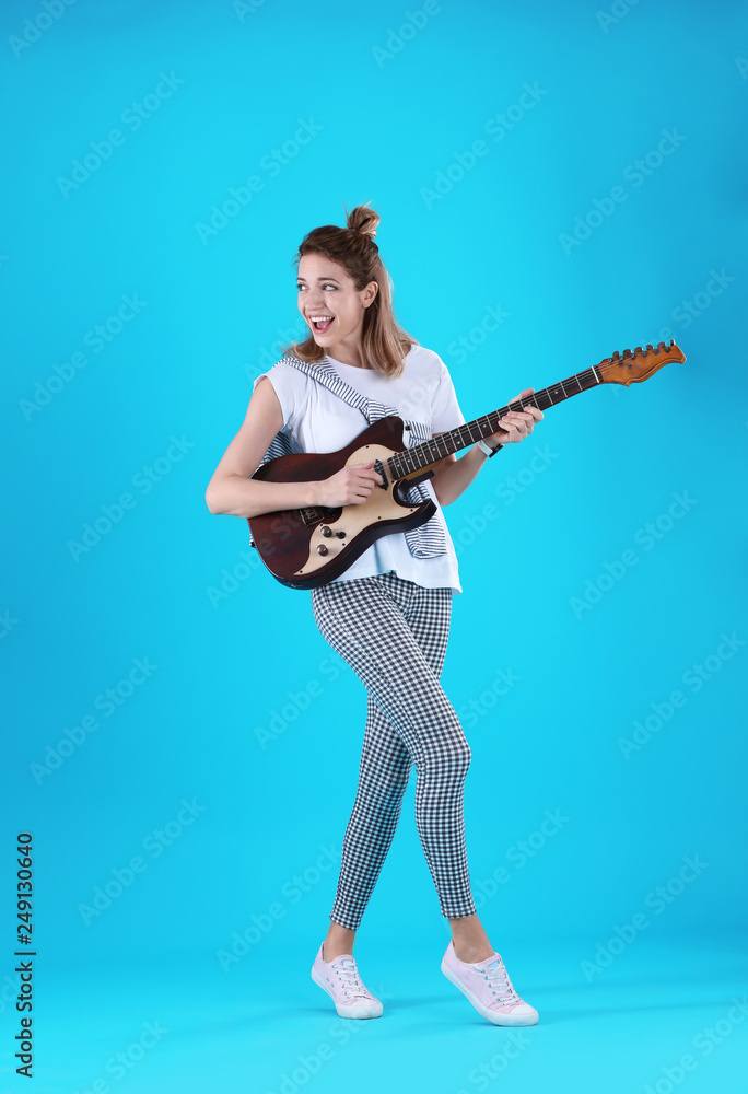 Young woman playing electric guitar on color background Young woman playing electric guitar on color background