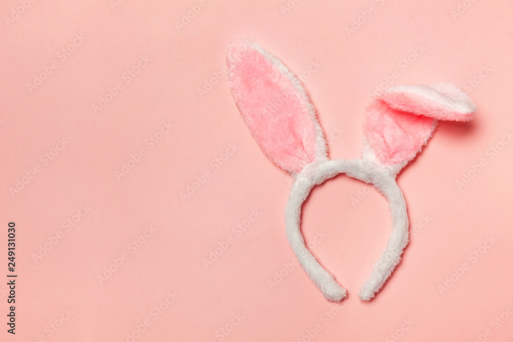 Happy Easter concept. Preparation for holiday. Decorative bunny ears furry fluffy costume toy isolated on trendy pastel pink background. Simple minimalism flat lay top view copy space