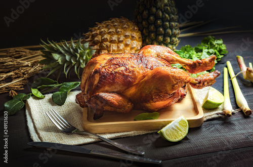 Baked chicken placed on a Wooden plate photo