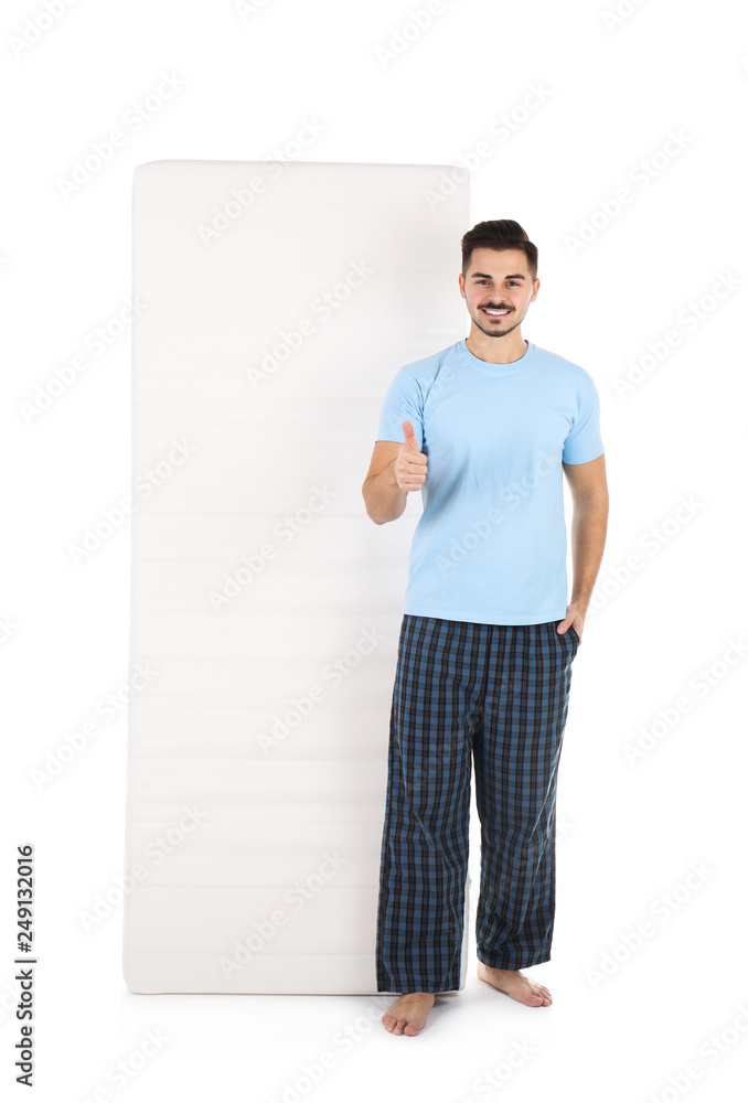 Young man with comfortable mattress isolated on white Young man with comfortable mattress isolated on white