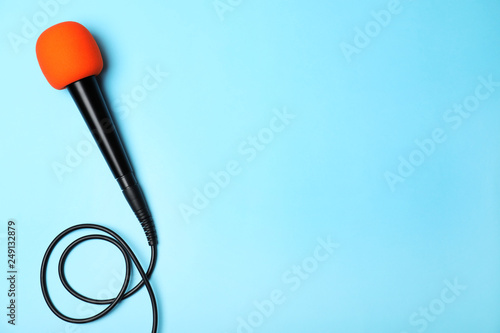Dynamic microphone on color background, top view with space for text