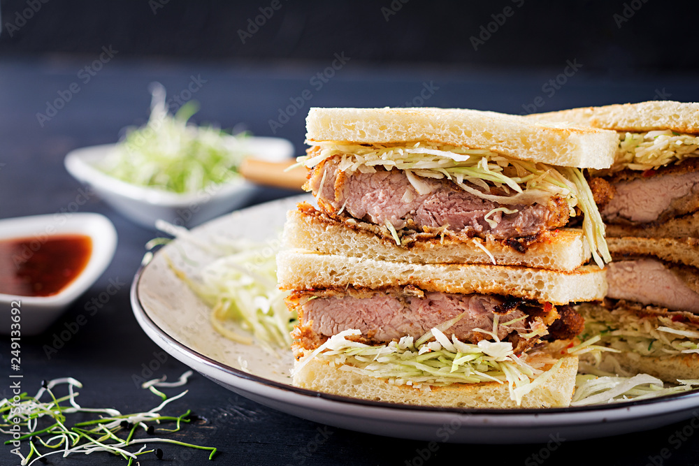 Katsu Sando - food trend japanese sandwich with breaded pork chop, cabbage and tonkatsu sauce. Japanese cuisine. Katsu Sando - food trend japanese sandwich with breaded pork chop, cabbage and tonkatsu sauce. Japanese cuisine.