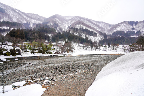 Villages of Shirakawago and Gokayama are one of Japan's UNESCO World Heritage Sites. Farm house in the village and mountain behind. photo