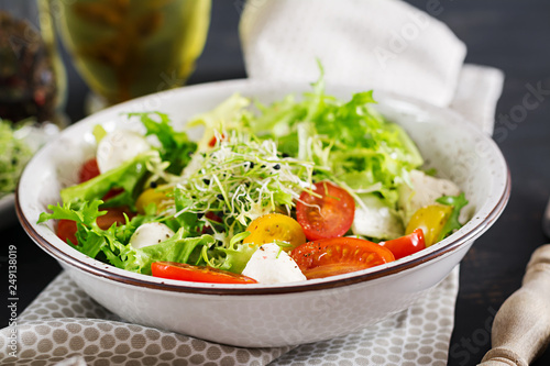 Vegetarian salad with cherry tomato, mozzarella and lettuce. Italian cuisine.