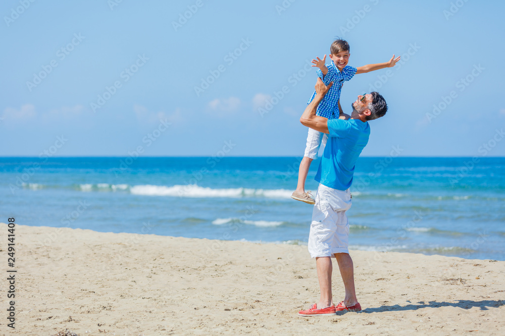 Father and son playing at beach together.