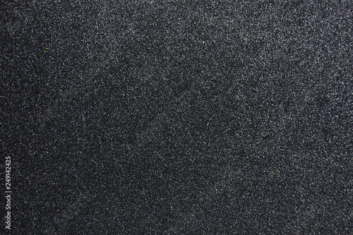 Bumpy black glitter textured background, Closeup