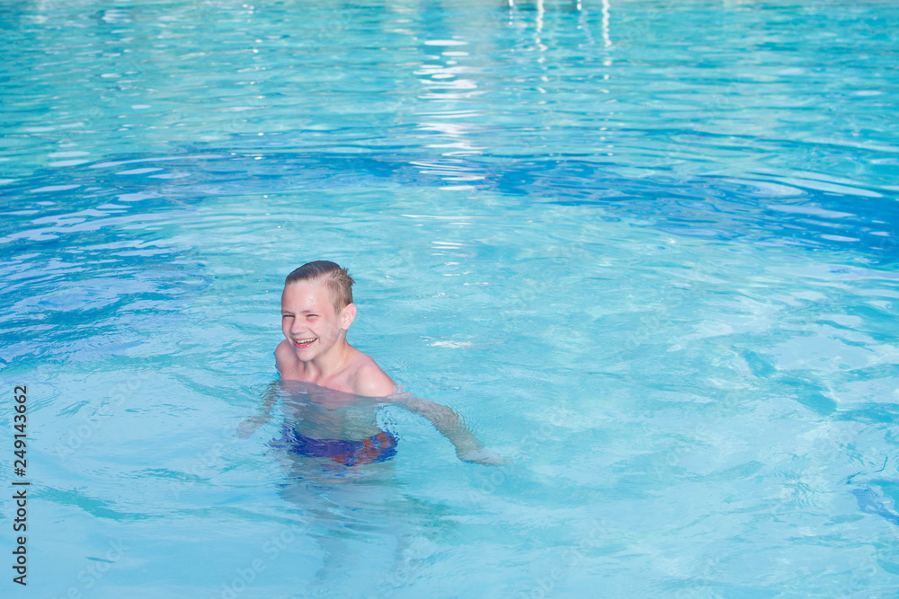 Boy swimming of swimming pool. Cute teenage boy. Aquapark