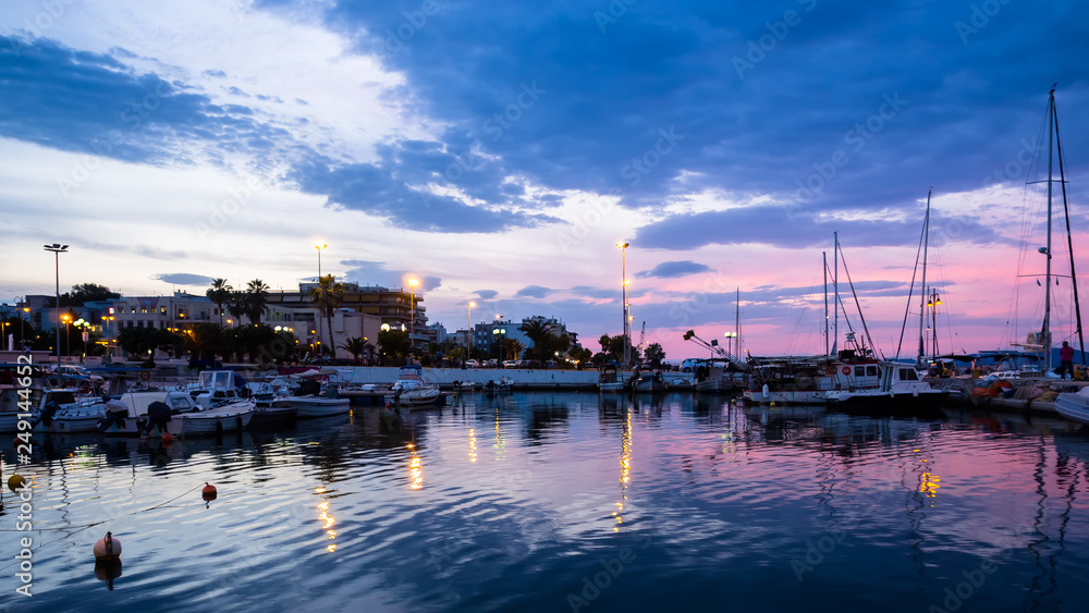 View of Corinth port with boats and piers shot at blue and pink dusk