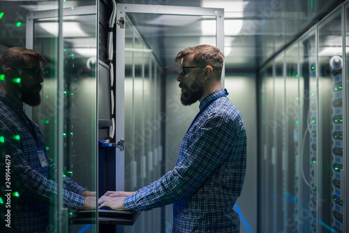 Obraz na płótnie Bearded IT specialist setting servers in data center