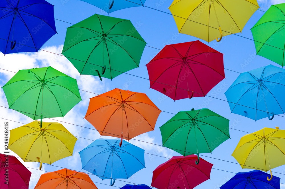 colorful umbrellas, white, blue, green, red and yellow against the background of the summer sky, umbrellas of different colors from the sun