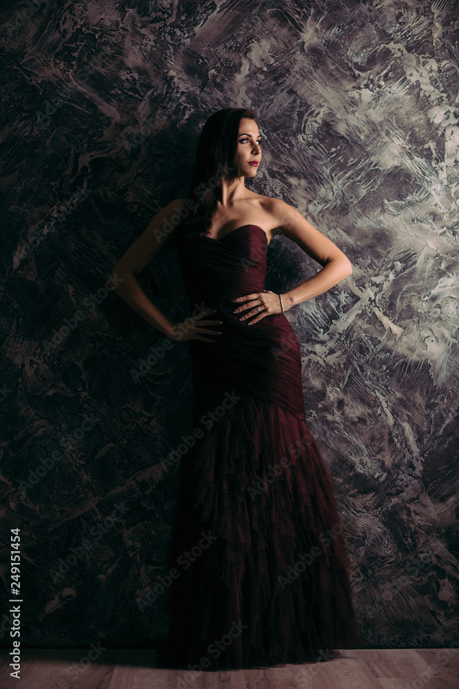 Fototapeta premium gorgeous sexy woman in evening dress posing over dark background