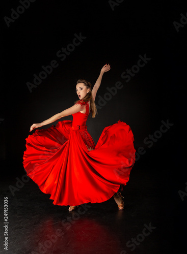 Young beautiful female flamenco dancer posing on a studio background