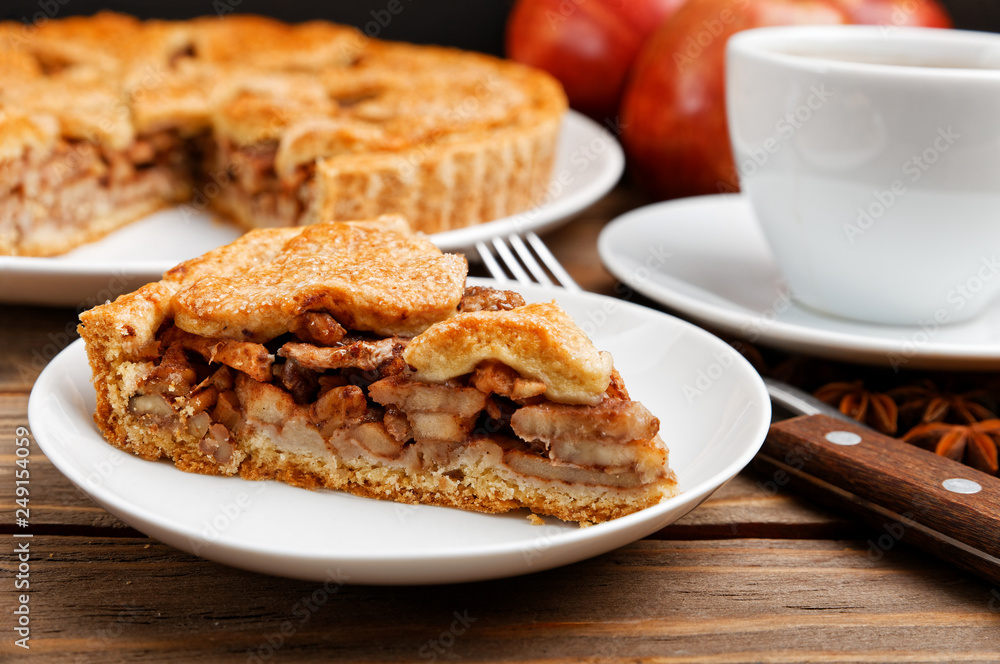 Closeup piece of homemade apple pie with cinnamon and cup of tea on wooden table. Shallow focus. Closeup piece of homemade apple pie with cinnamon and cup of tea on wooden table. Shallow focus.