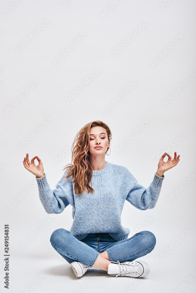 Finding the balance. Brown-haired, cute girl sitting on the floor, in ...