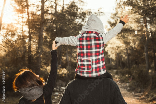 Happy family playing in the countryside. Child on his father's shoulders