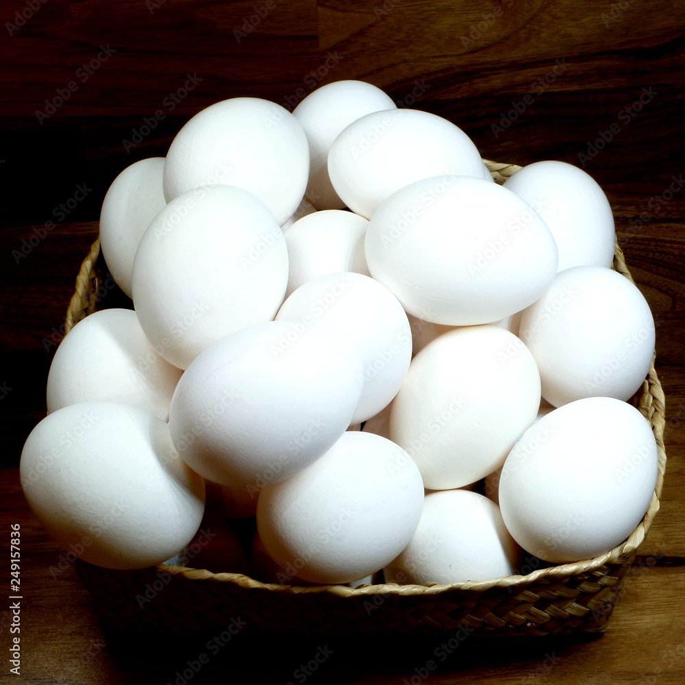 White chicken eggs in a straw basket close-up White chicken eggs in a straw basket close-up