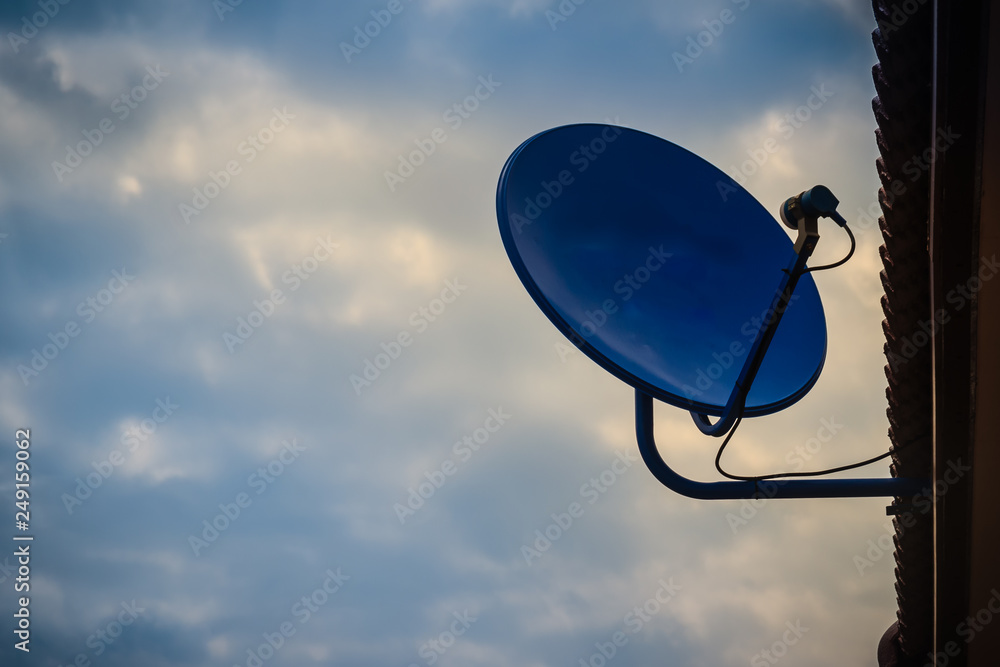 Blue telecommunication TV dish with receiver against clouds and blue sky in the morning.