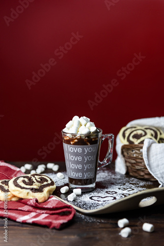 Hot chocolate with marshmallows and cookies on a red background