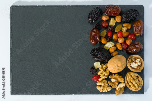 Still life from nuts and dried fruits on a slate plate.